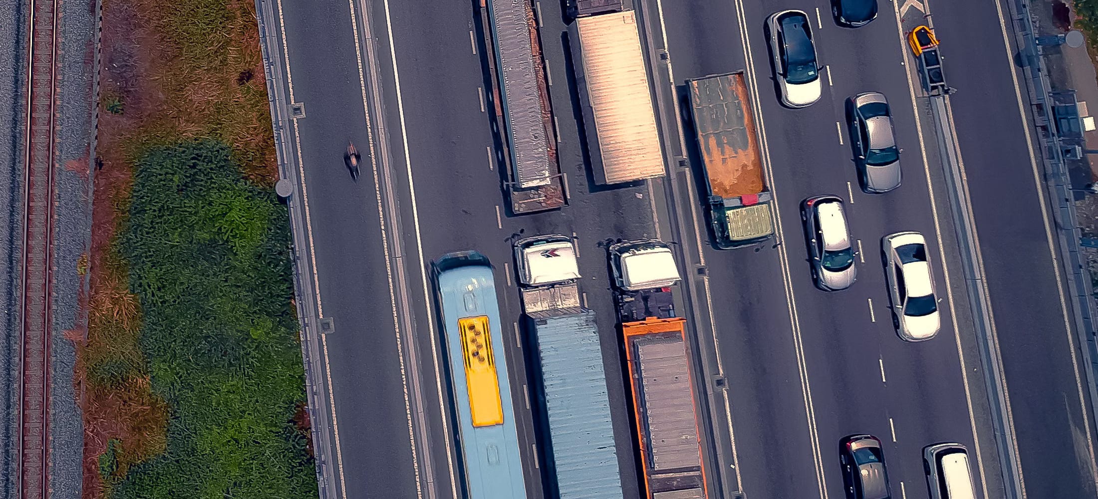 Tratto autostradale a pi&ugrave; corsie ripreso al tramonto, con carreggiata strumentata